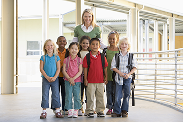 teacher posing with a group of young students