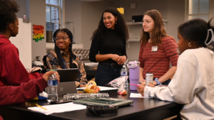 Shaniya with TA and students at a table talking