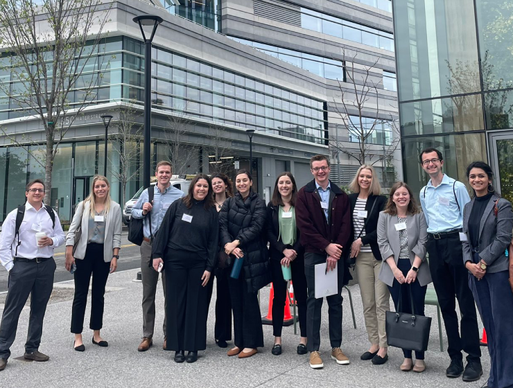 A group of trainees posing in front of a building