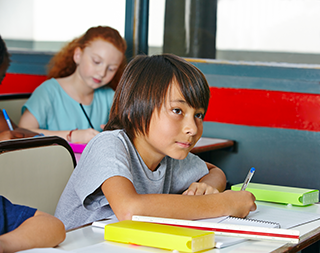 boy writing at desk