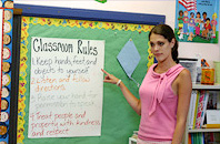 Teacher pointing to a poster on a board
