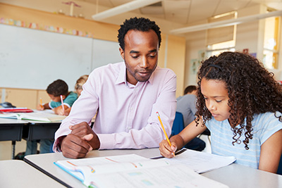 teacher watching student at writing task