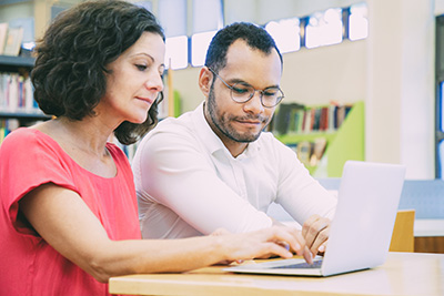 two adults on laptop