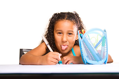 girl at desk sticking out her tongue