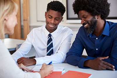 young man meeting with teacher and parent