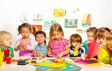 young children working at a table with materials