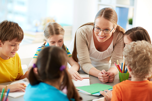 teacher conferring with small group at table