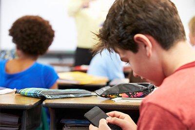 boy using phone at desk