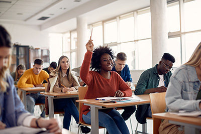 student raising hand from desk
