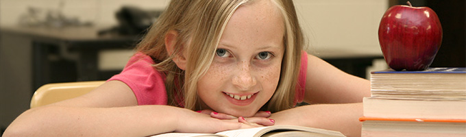 Student with book and smiling at the camera