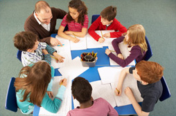 kids sitting with the teacher at a table