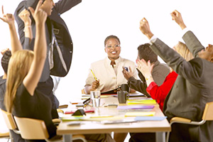 Adults cheering at a meeting