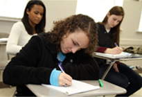 Estudiantes escribiendo en sus escritorios