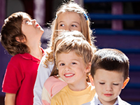 four smiling children outside