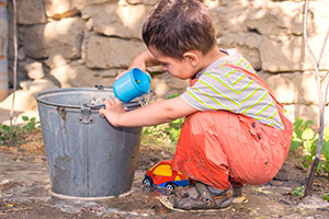 boy playing with cup and bucket