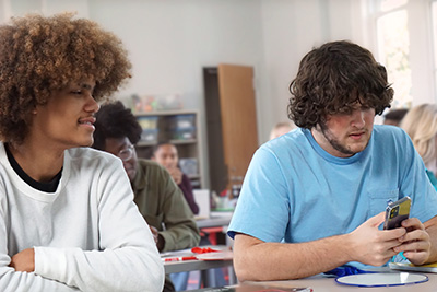 one student watches another using his phone