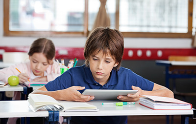 boy working at desk using a digital device