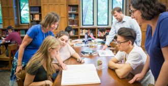 librarians around a reading table assist students