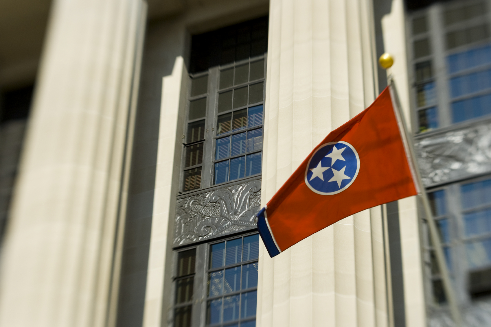 Tennessee state flag flying in front of the capitol building.