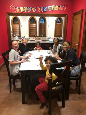 Audrey Bowden and her family with undergraduate students in her Zeppos apartment (Submitted photo)