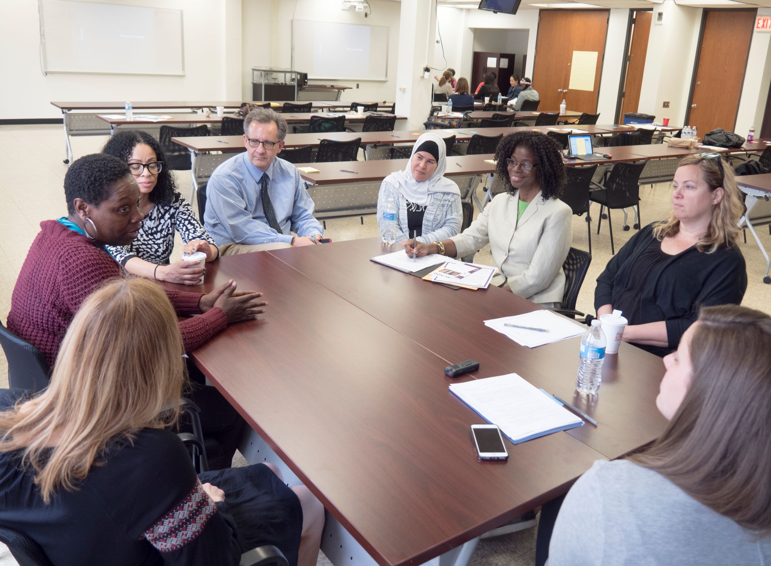 Adults sit around a table for a focus group discussion