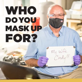 man holding up white board