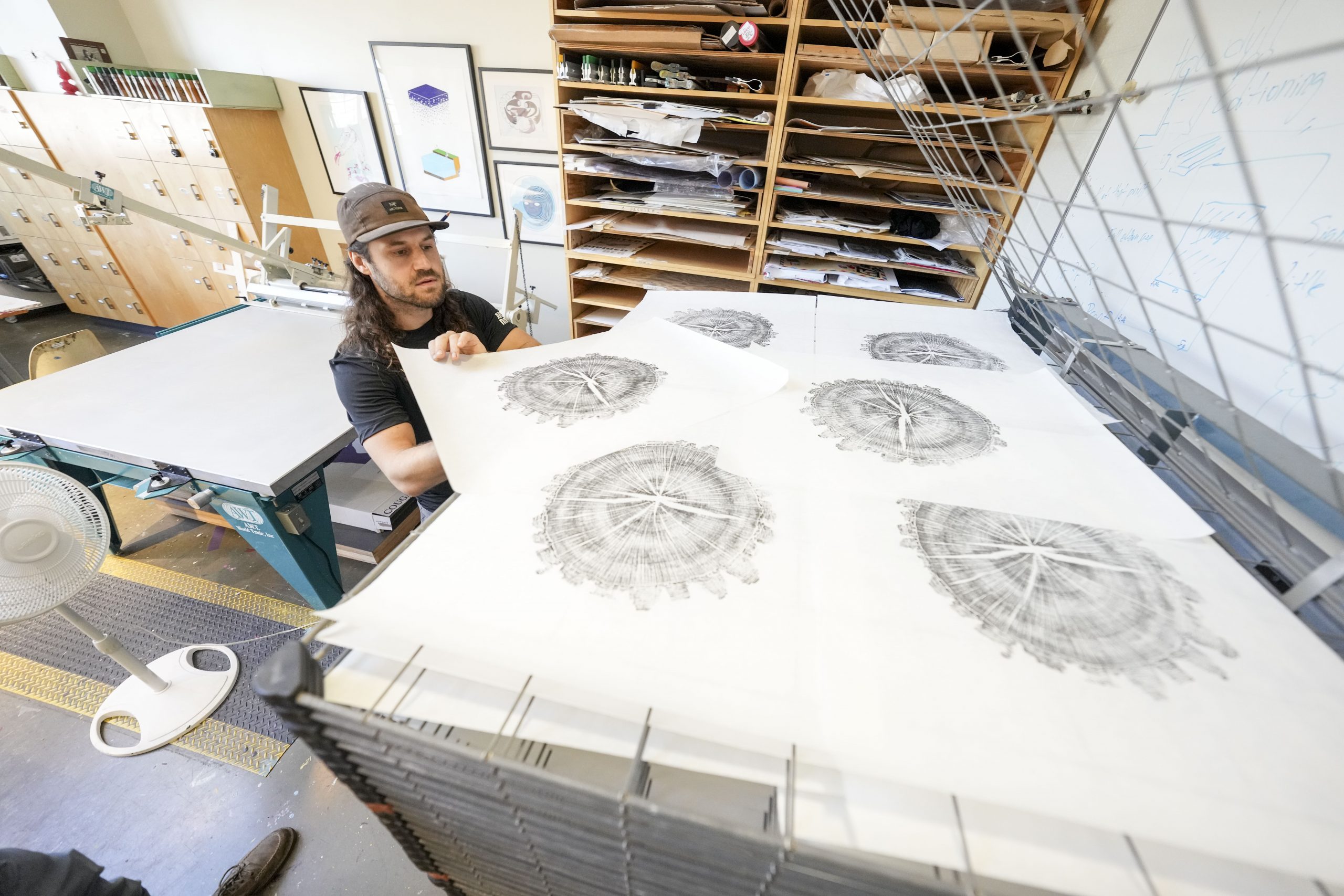 Art students watch as Artist Marko Barakoski makes tree prints at  Ingram Fine Arts studio using the wood from the Bicentennial Oak that fell on campus in 2022.