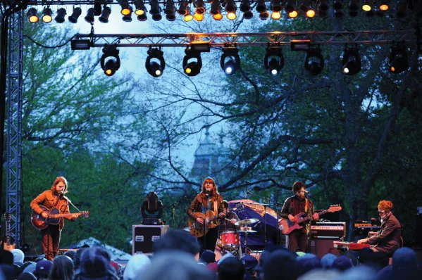 A band playing for the annual Rites of Spring weekend with campus buildings in the background