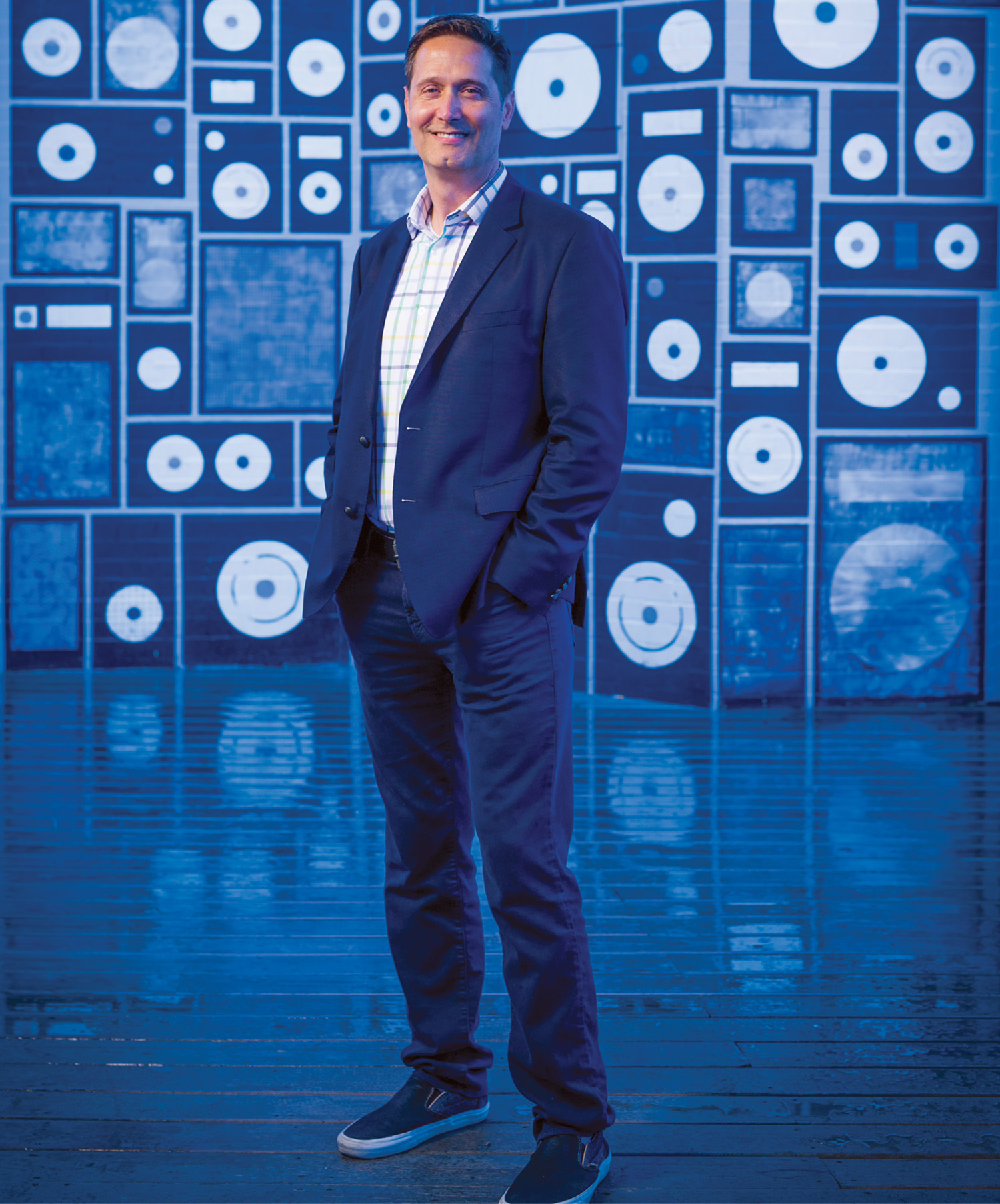 photo of Mitch Glazier standing in front of music store mural