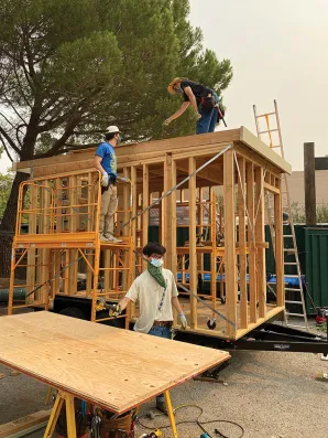 Sean Ticknor and members of his Big Skills Tiny Home team work on structures that help the high school-aged team members learn many aspects of homebuilding. (Courtesy of Big Skills Tiny Homes)