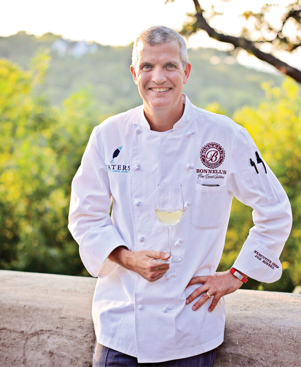 photo of Jon Bonnell in a chef's apron holding a wine glass