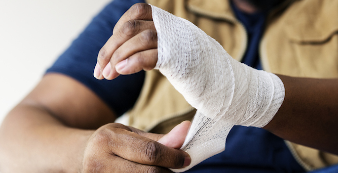 african american man wrapping gauze around his hand