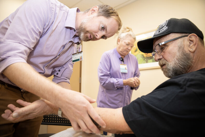 Cosby Stone Jr., MD, MPH, examines patient Gregory Barker’s arm following Barker’s allergy test. (photo by Erin O. Smith)