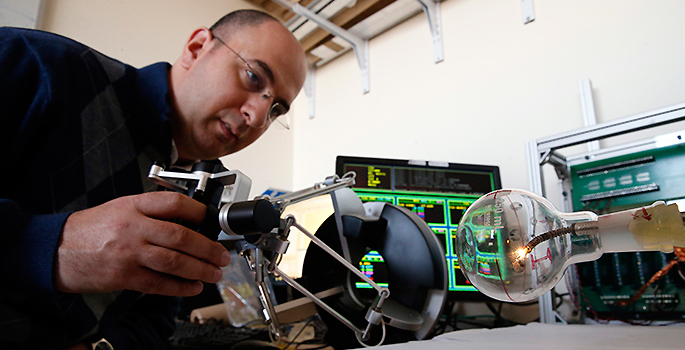 portrait in lab manipulating surgical robot