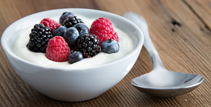 Bowl of fresh mixed berries and yogurt with farm fresh strawberries, blackberries and blueberries served on a wooden table (Bowl of fresh mixed berries and yogurt with farm fresh strawberries, blackberries and blueberries served on a wooden table