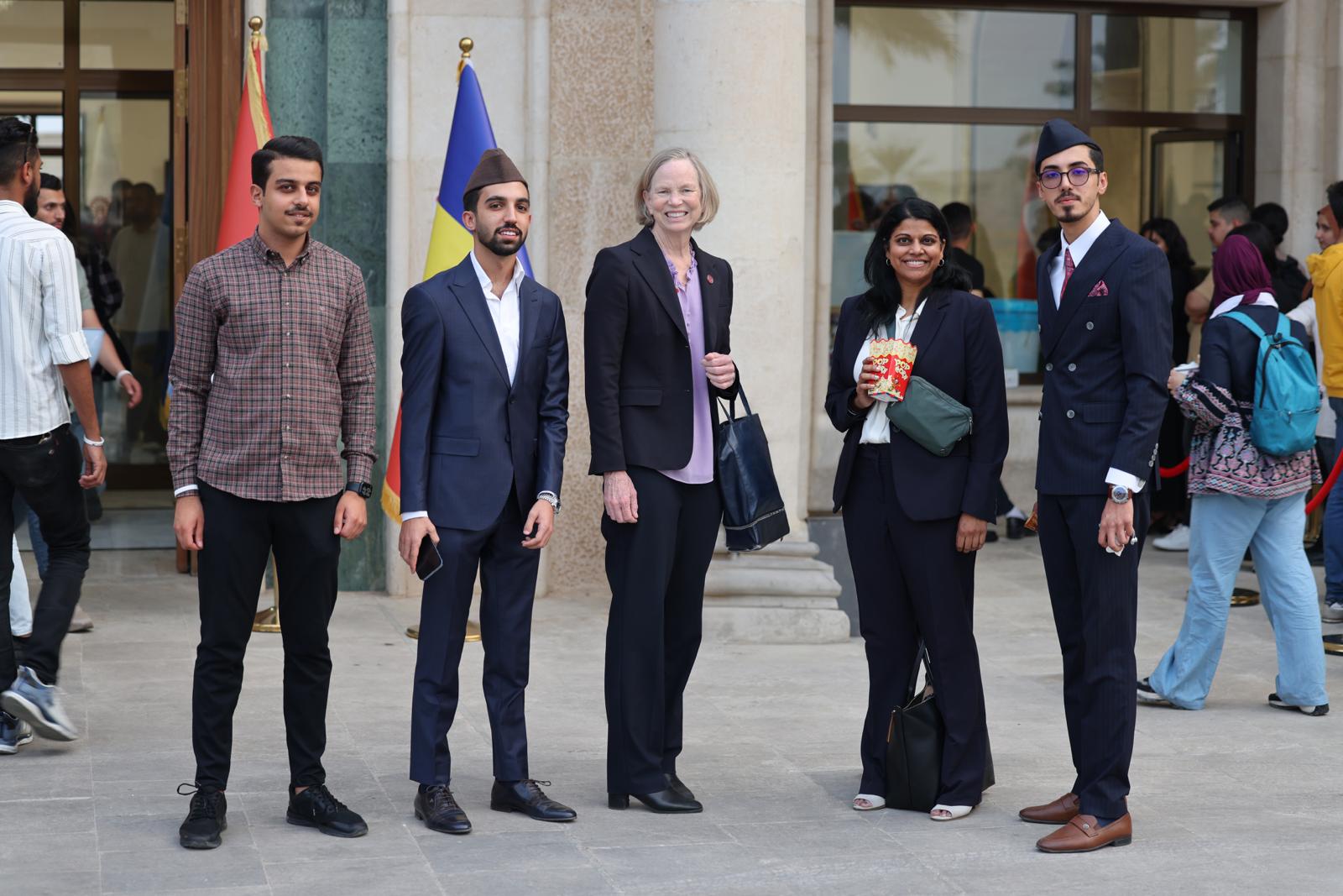 College students standing with university faculty
