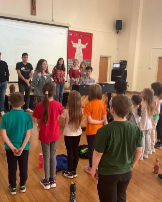 Junior Music Education major Ellie Repp teaching a song with organ scholar Caius Lee