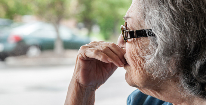 Elderly woman looking out window