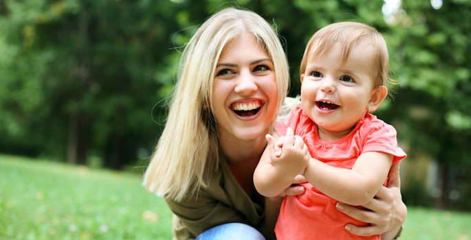 Caucasian mom and toddler daughter playing in the park