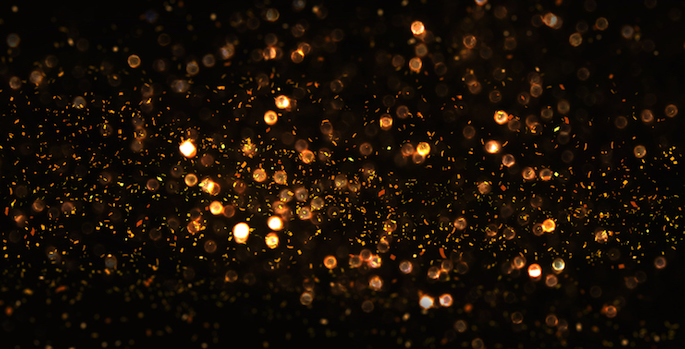 Gold glitter scattered on black background