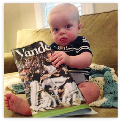 Photo of baby reading magazine