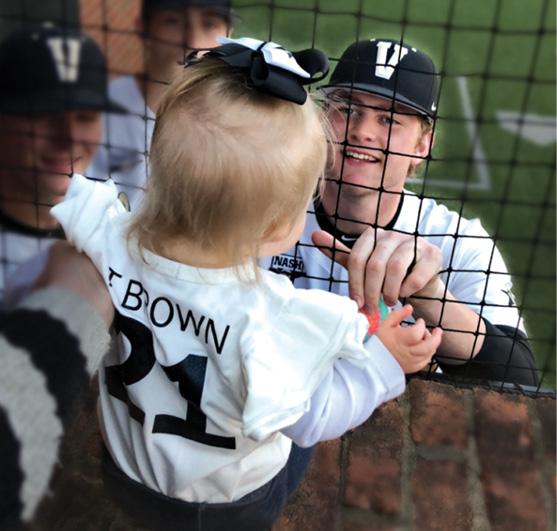 photo of Tyler Brown visiting with Bella in the dugout