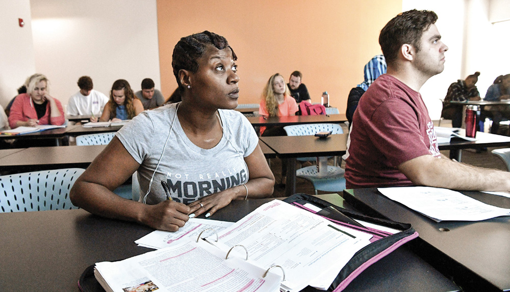 photo of an African American woman listening to a classroom instructor