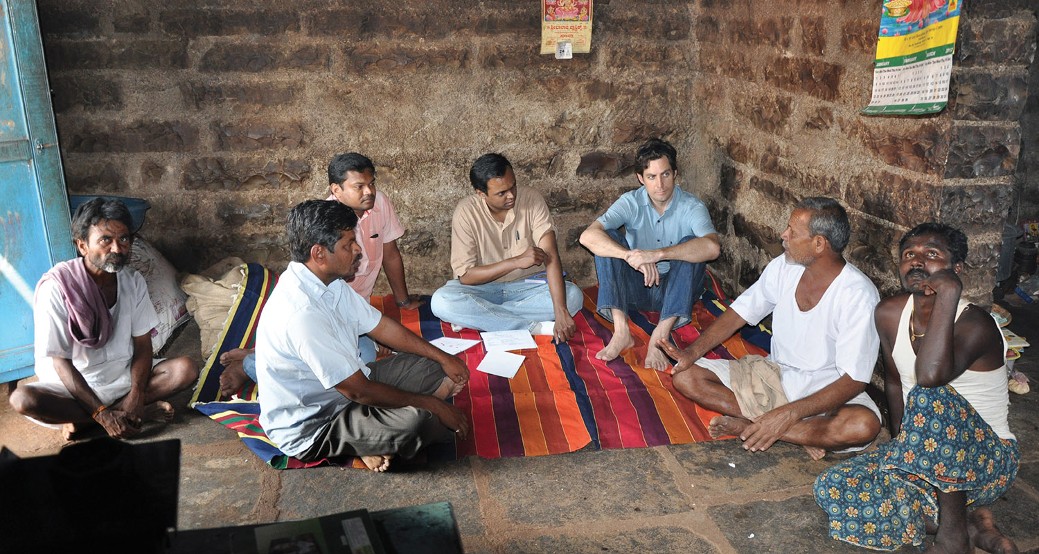 Michael MacHarg (third from right), senior director of social ventures for Mercy Corps and co-founder of Simpa Energy, interviews a homeowner in a village without electricity in rural Karnataka, India, with two of his Simpa colleagues. (COURTESY MICHAEL MACHARG)