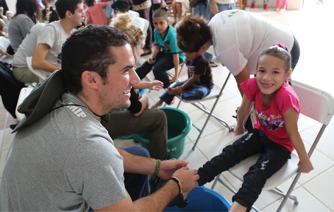photo of Taylor Hudson helping young girl