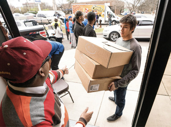 photo of students distributing supplies in neighborhood damaged by tornadoes