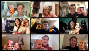 Students show off a Halloween craft they made together.