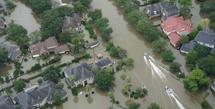 overhead photo of boats floating through flooded neighborhood