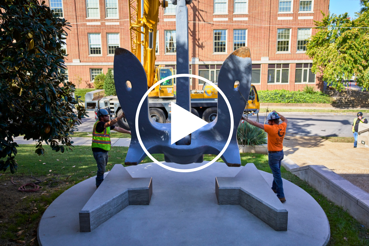 Image Description: Workers placing anchor on campus from USS Nashville.