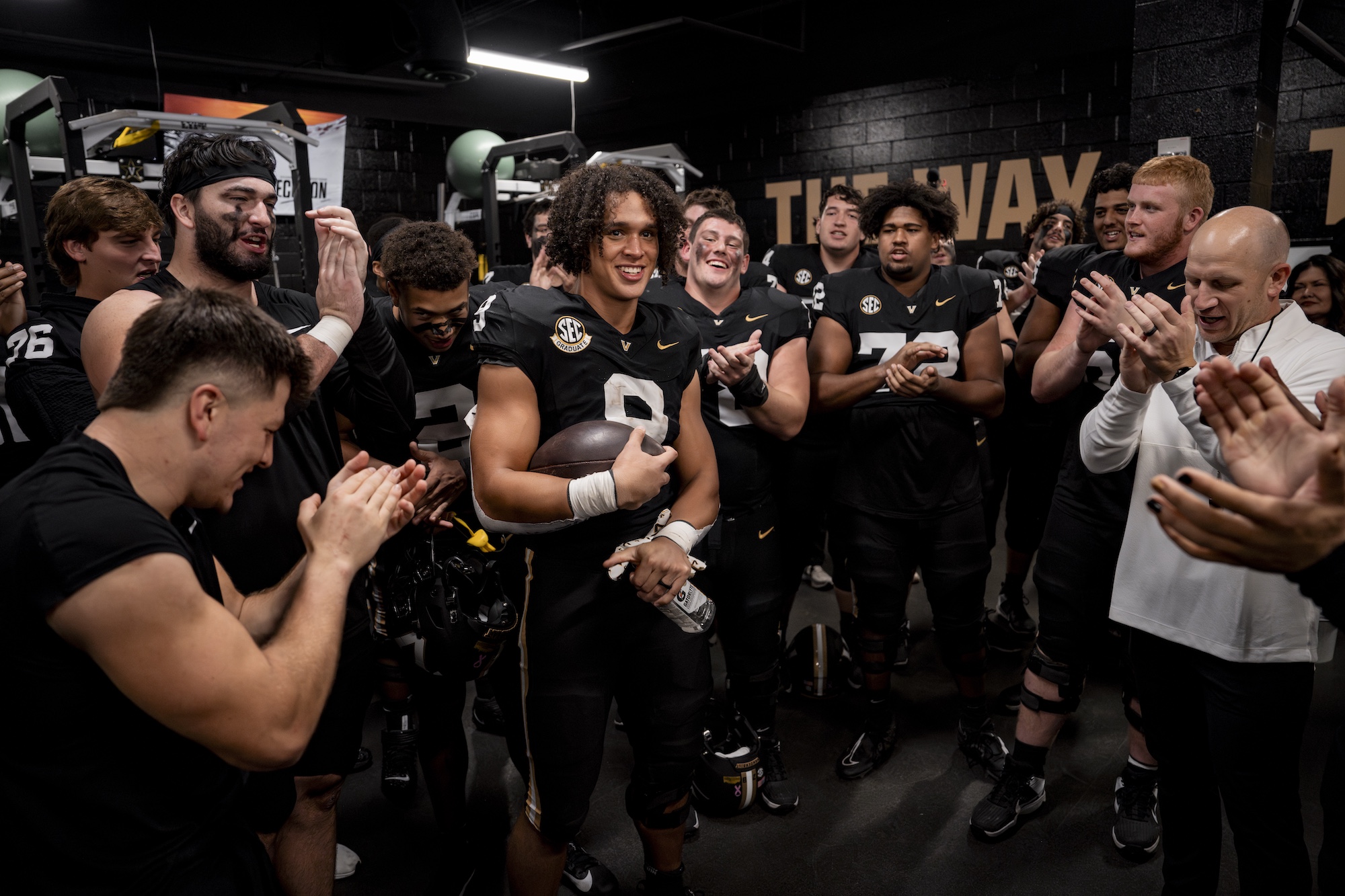 Football players and Head Coach Clark Lea cheer in the locker room during the Ball State game. 